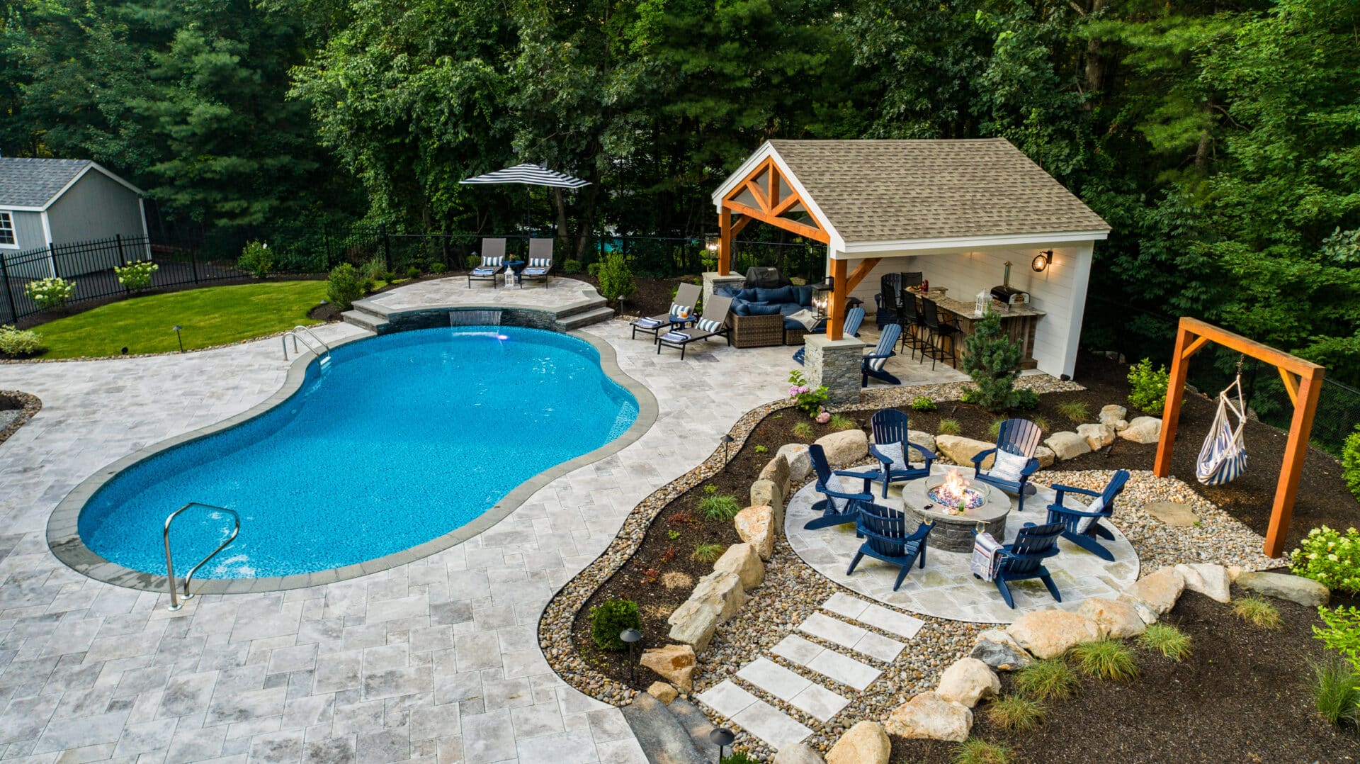 Drone shot of a new Dex By Terra pool deck, patio and fire pit in Whittinsville MA.