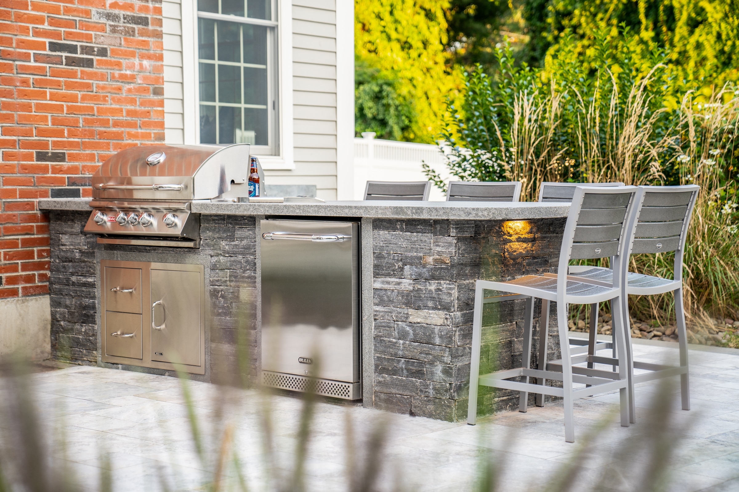 Outdoor kitchen with stone veneer and granite countertop. Dex by Terra Landscape design project in Andover, Massachusetts.