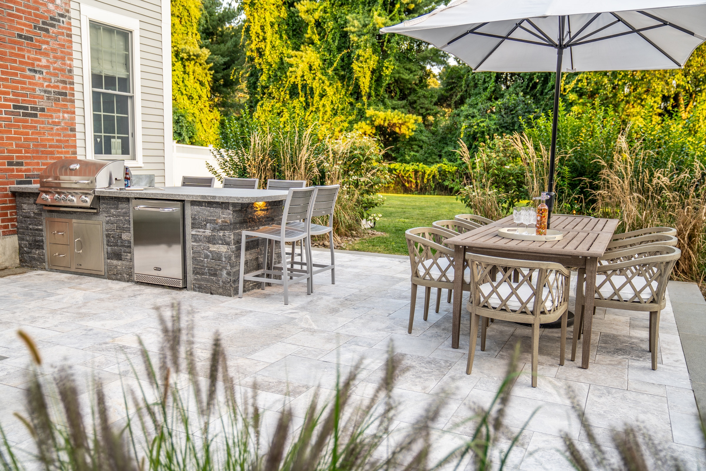 Granite and stone veneer outdoor kitchen on patio. Dex by Terra Landscape design / build project in Andover, Massachusetts.