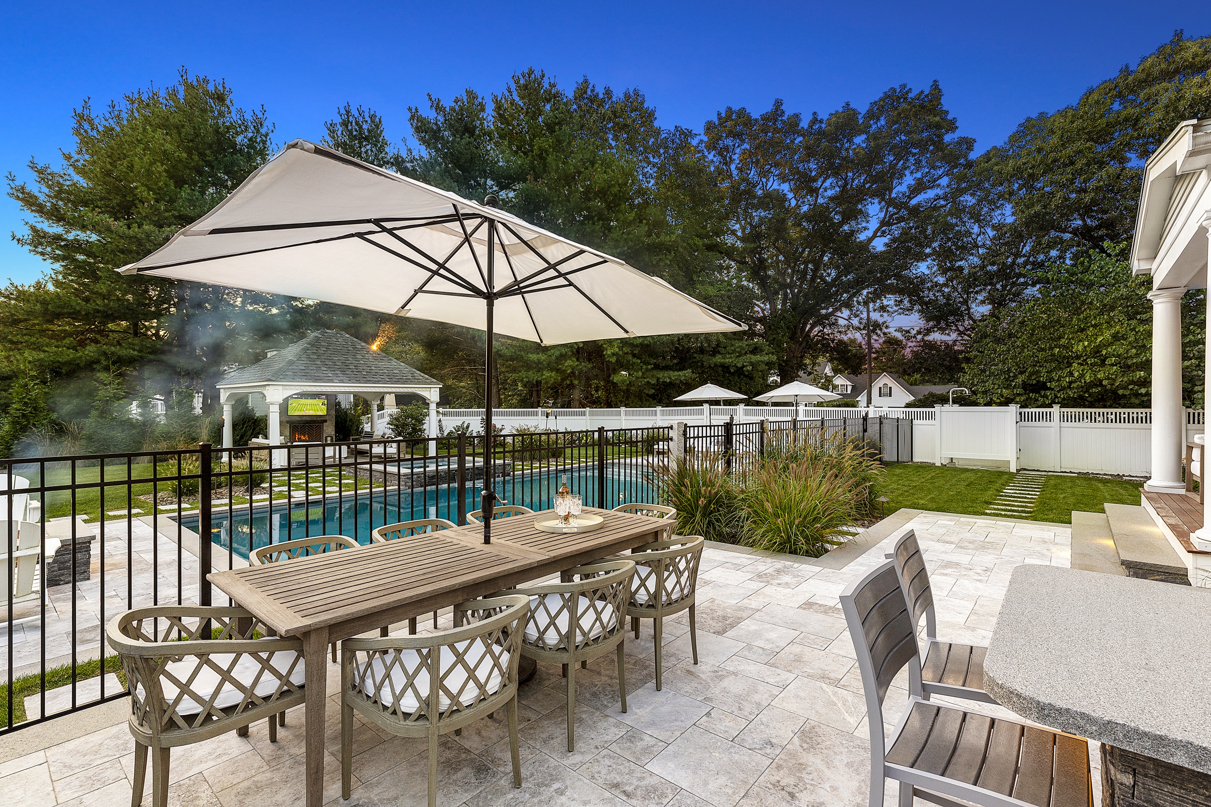 Stone paver patio with pool and gazebo. Dex by Terra Landscape design / build project in Andover, Massachusetts.