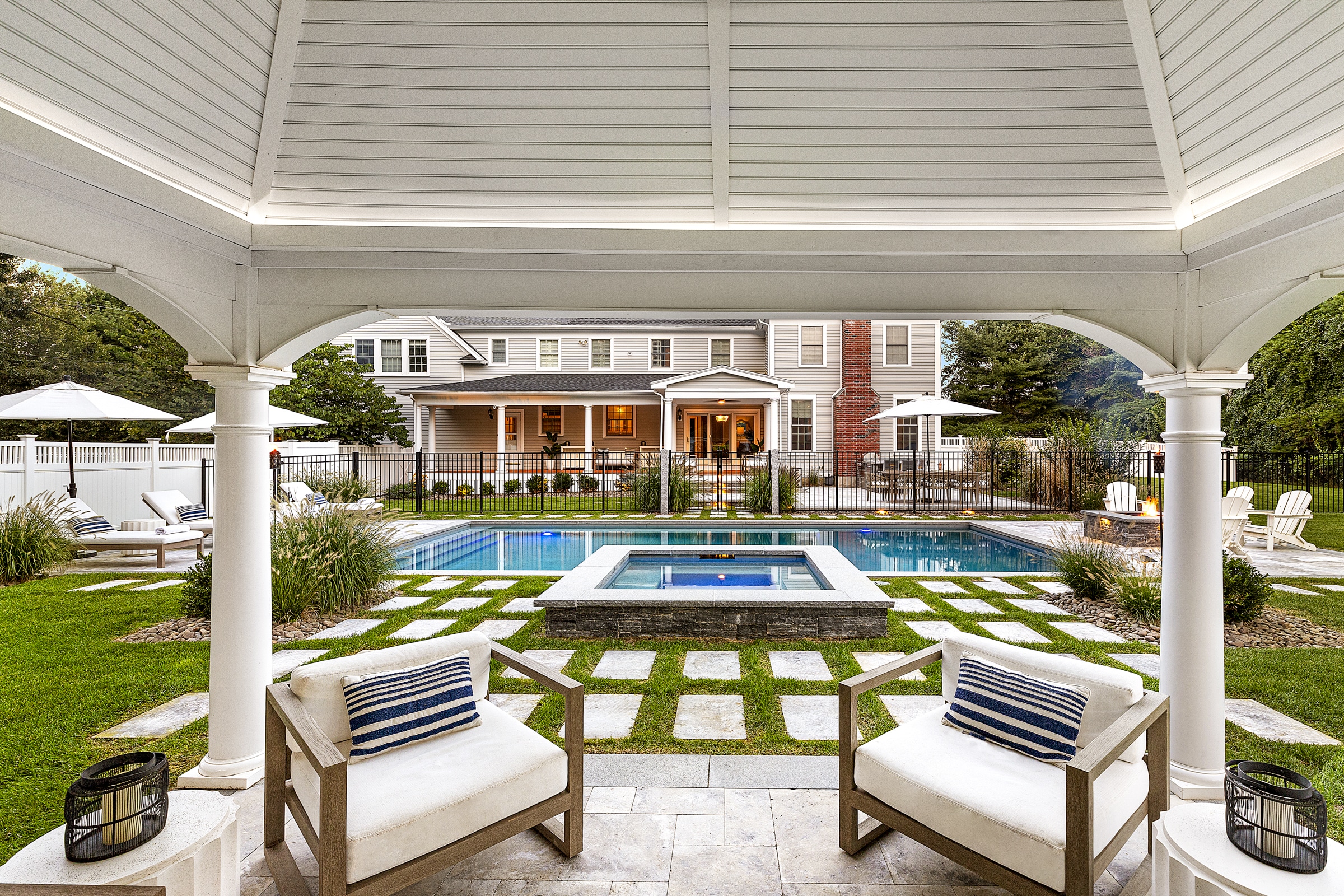 Stone paver patio with spa, pool, and fire pit. Dex by Terra Landscape design / build project in Andover, Massachusetts.