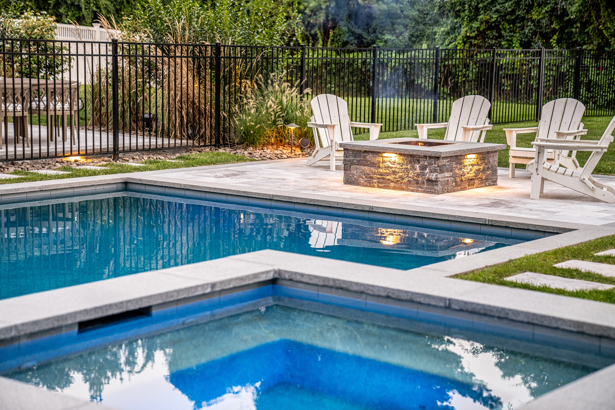 Pool with poolside spa and fire pit. Dex by Terra Landscape design / build project in Andover, Massachusetts.