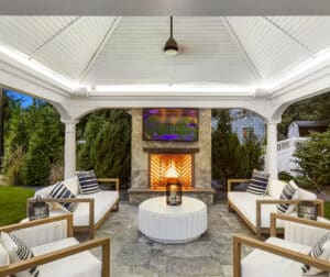 Gazebo patio with stone fireplace and TV. Dex by Terra Landscape design / build project in Andover, Massachusetts.