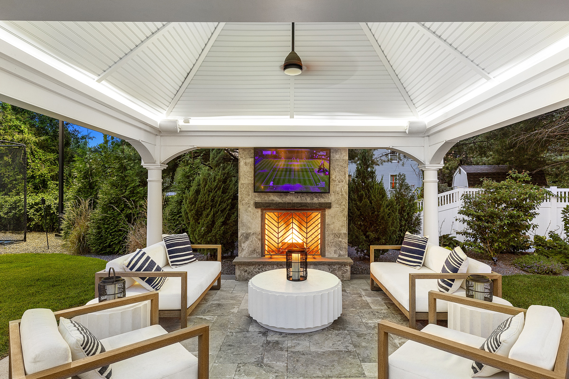 Gazebo patio with stone fireplace and TV. Dex by Terra Landscape design / build project in Andover, Massachusetts.