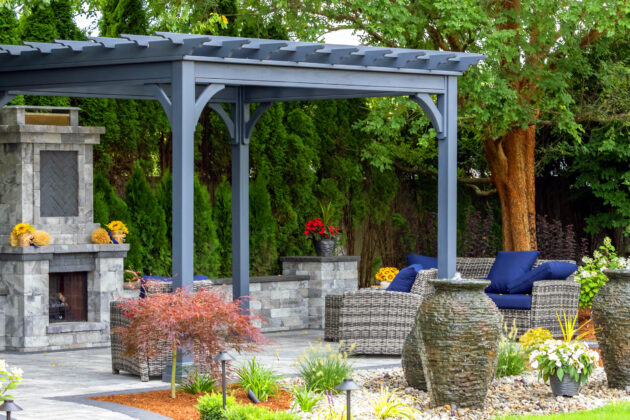 An Outdoor Structure in Massachusetts - pergola, stone fireplace, and elegant urn water fountains for a serene outdoor space.